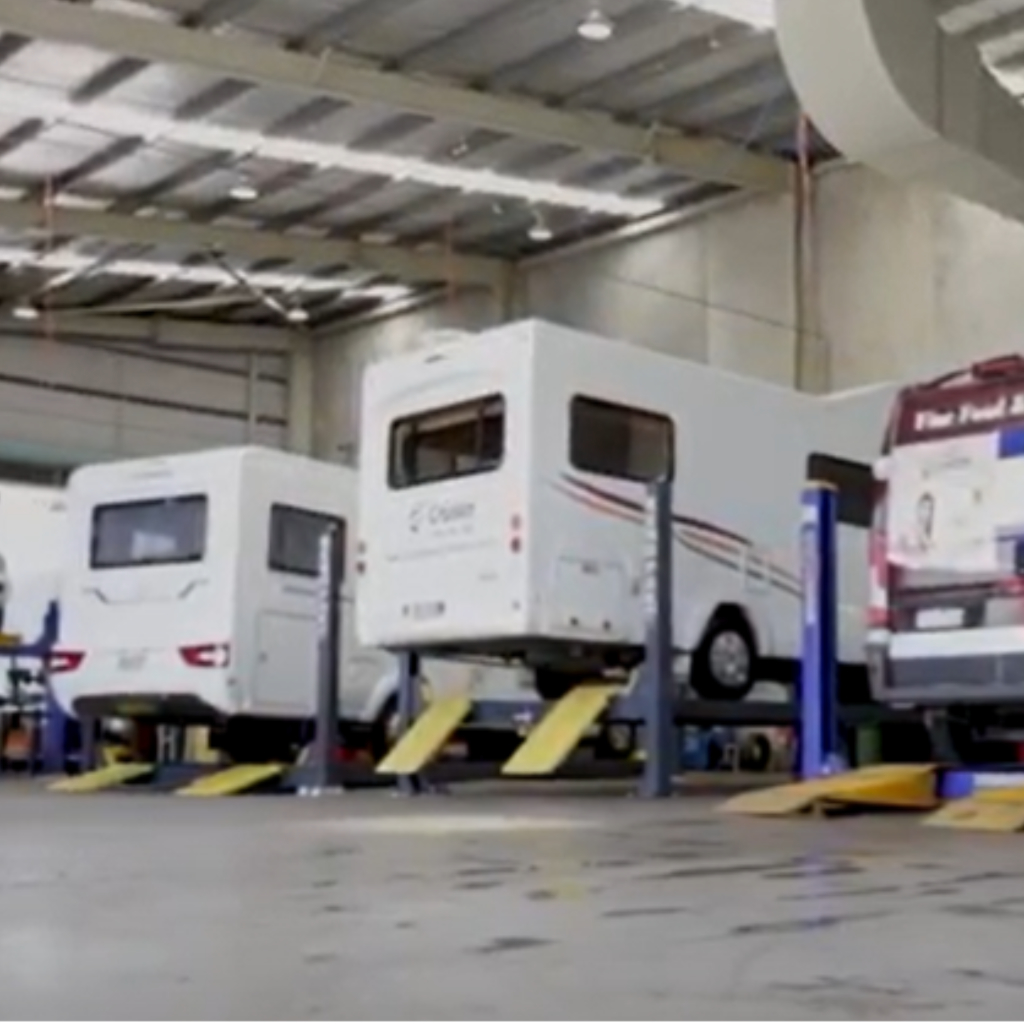 Motorhomes raised on hoists in the East Coast Commercials workshop