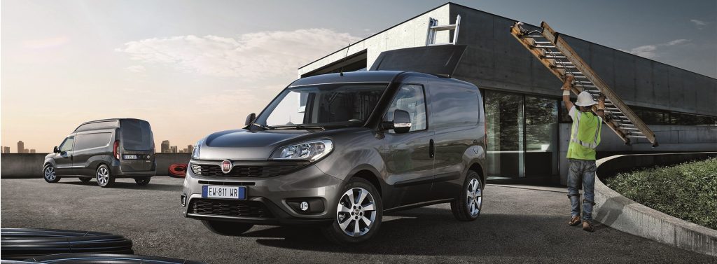 Grey Fiat Doblo vans at a building site